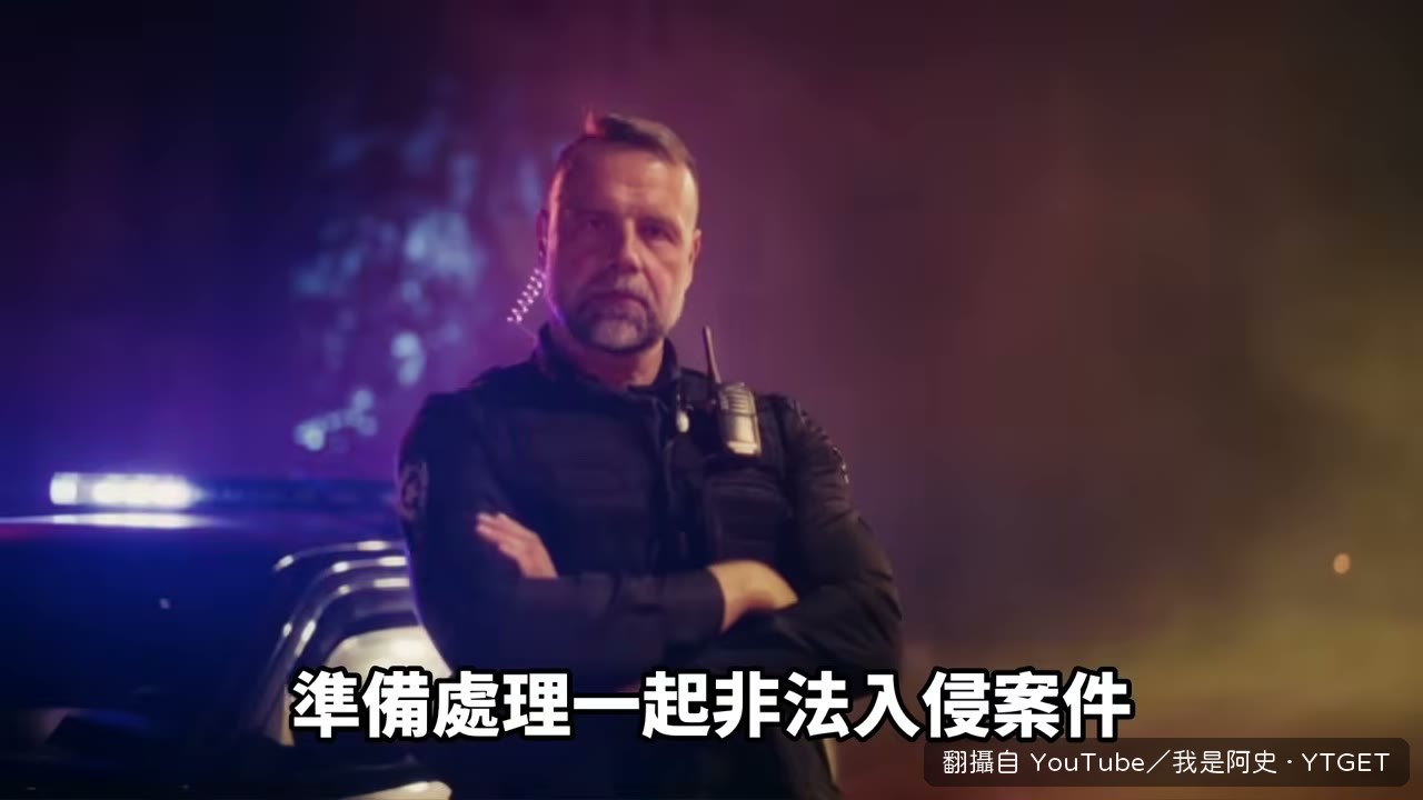 納森被上銬站在車旁